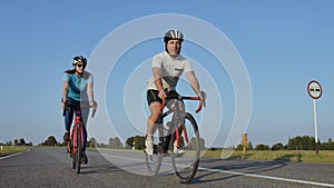 Hard Training.Triathlete two Cyclist Training On Road Bicycle. two Cyclist Riding On Road Bike In City Park And Getting