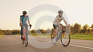 Hard Training.Triathlete two Cyclist Training On Road Bicycle. two Cyclist Riding On Road Bike In City Park And Getting