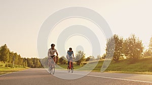 Hard Training.Triathlete two Cyclist Training On Road Bicycle. two Cyclist Riding On Road Bike In City Park And Getting