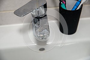 Hard water residue and toothpaste dirt on the bathroom tap