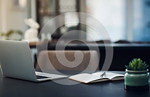 Hard work is exactly what it takes to succeed. Still life shot of a laptop and notebook on a table in an office.