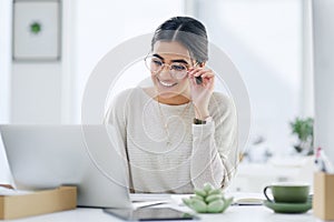 Hard work is the first step towards smart work. a young businesswoman working on a laptop in an office.