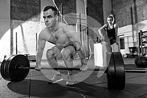 Hard working strong bodybuilder preparing to lift a barbell