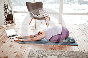 Hard-working woman in violet leggings stretching all body muscles