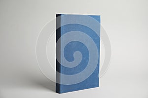 Hardcover book on light grey background. Space for design