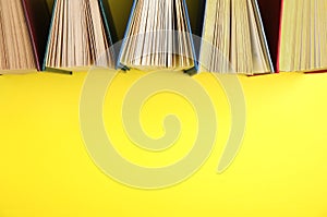 Hardcover books on yellow background. Space for text