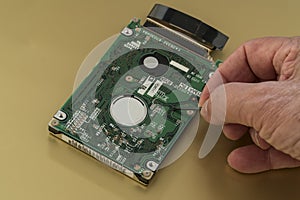 Harddrive  from a laptop computer is being inspected by a technician