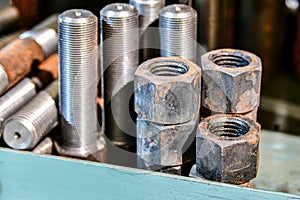 Hardened nuts on a rack before tapping on a lathe