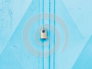 Hardened padlock hang in eye bolt on blue industrial metal door