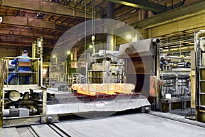 Hardening of steel components in a foundry - red-hot components come out of the oven