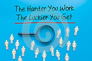 The Harder You Work The Luckier You Get  Sign on white paper. Man Hand Holding Paper with text. Isolated on Workers concept, photo