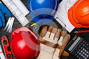 Hardhat, gloves and blueprints of a builder