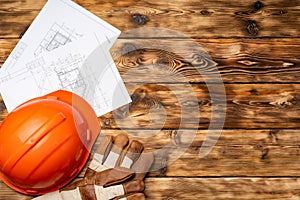 Hardhat, gloves and blueprints of a builder