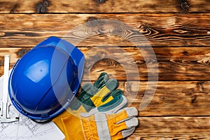 Hardhat, gloves and blueprints of a builder