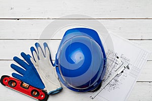 Hardhat, gloves and blueprints of a builder