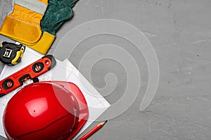 Hardhat, gloves and blueprints of a builder