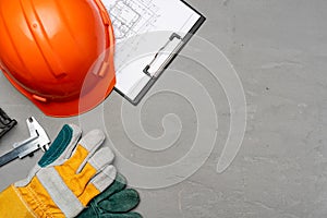 Hardhat, gloves and blueprints of a builder