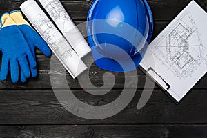 Hardhat, gloves and blueprints of a builder