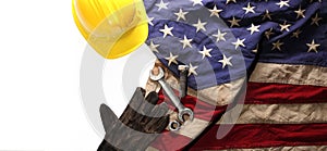 Hardhat, gloves, and tools on US American flag. Strong American workforce or industry, or America labor day concept. Blank copy