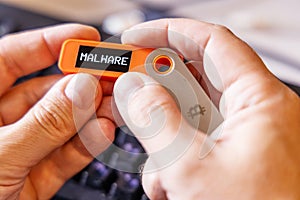 hardware Bitcoin wallet in a hands with Malware message on screen