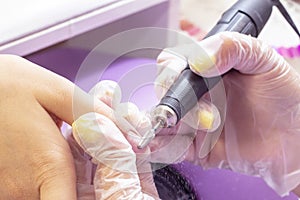 Hardware manicure. Gellak removal shellac coating nail plate treatment with manicure machine photo