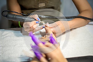 Hardware manicure. Removal of old gel varnish in the salon. Manicure master doing beauty procedure for client, closeup and top vie