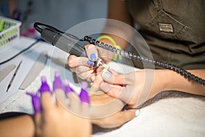 Hardware manicure. Removal of old gel varnish in the salon. Manicure master doing beauty procedure for client, closeup and top vie