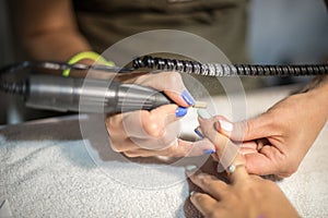 Hardware manicure. Removal of old gel varnish in the salon. Manicure master doing beauty procedure for client, closeup and top vie