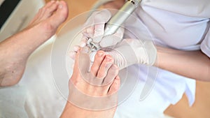 Hardware medical pedicure with nail file drill apparatus. Patient on pedicure treatment with pediatrician chiropodist