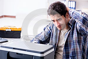 The hardware repairman repairing broken printer fax machine