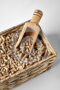 Hardwood Pellets used in pellet wood stoves in a wicker box and wooden scoop