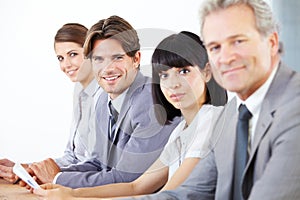 Hardworking business team. Portrait of a young handsome executive sitting with his business team.