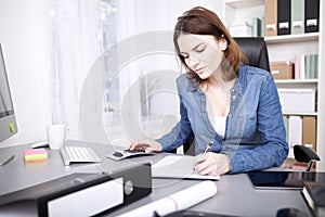 Hardworking businesswoman sitting writing a report