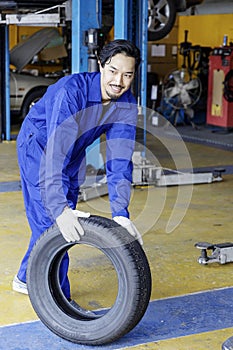 Hardworking experienced worker holding tire