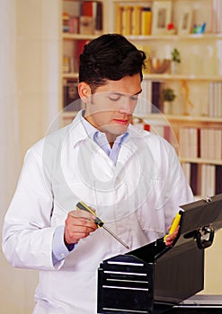 Hardworking Man apen a black tool box and holding a screwdriver in his hand