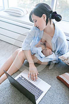 Hardworking mother freelance infant breastfeeding
