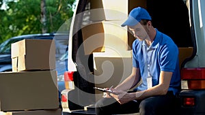 Hardworking postman checking amount of boxes, responsible job, inventory