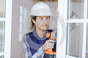 hardworking woman drilling window