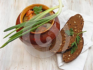 Hare wild rabbit with vegetables Goulash in Copper Pot on Wooden Surface, roasted beef meat with carrot, leek, onion in round cera