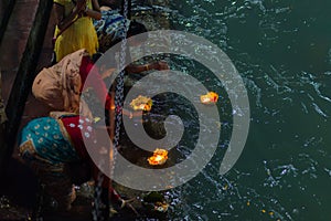 Haridwar, India - March 20, 2017: Holy ghats at Haridwar, India, sacred town for Hindu religion. Pilgrims offering floating flowe