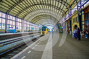 Harlem, Amsterdam, Netherlands - July 14, 2015: Inside railroad station, large roof covering platform, blue and yellow