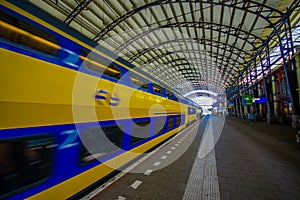 Harlem, Amsterdam, Netherlands - July 14, 2015: Inside railroad station, large roof covering platform, blue and yellow