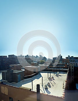 Harlem New York City building roof top with AC unites on a clear blue sky day