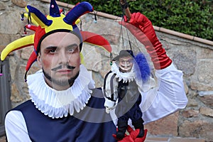 Harlequin puppeteer looking like his puppet doll