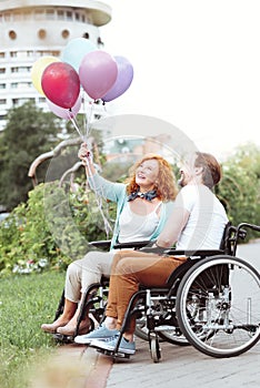 Harmonious couple smiling while looking at colorful balloons