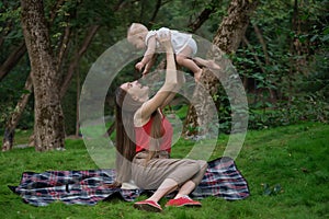 Harmonious family outdoors. Happy loving mother and her baby. Mom playing with child