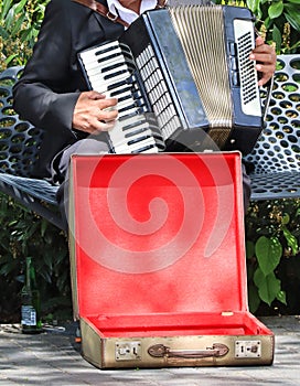 Harmonious man plays the accordion on the city street