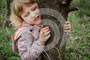 Harmonized with nature. Girl feels harmony with nature, hugging tree and feeling oneness with surrounding environment