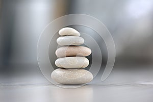 Harmony and balance, cairns, simple poise pebbles on wooden light white gray background, simplicity rock zen sculpture