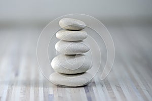 Harmony and balance, cairns, simple poise pebbles on wooden light white gray background, simplicity rock zen sculpture